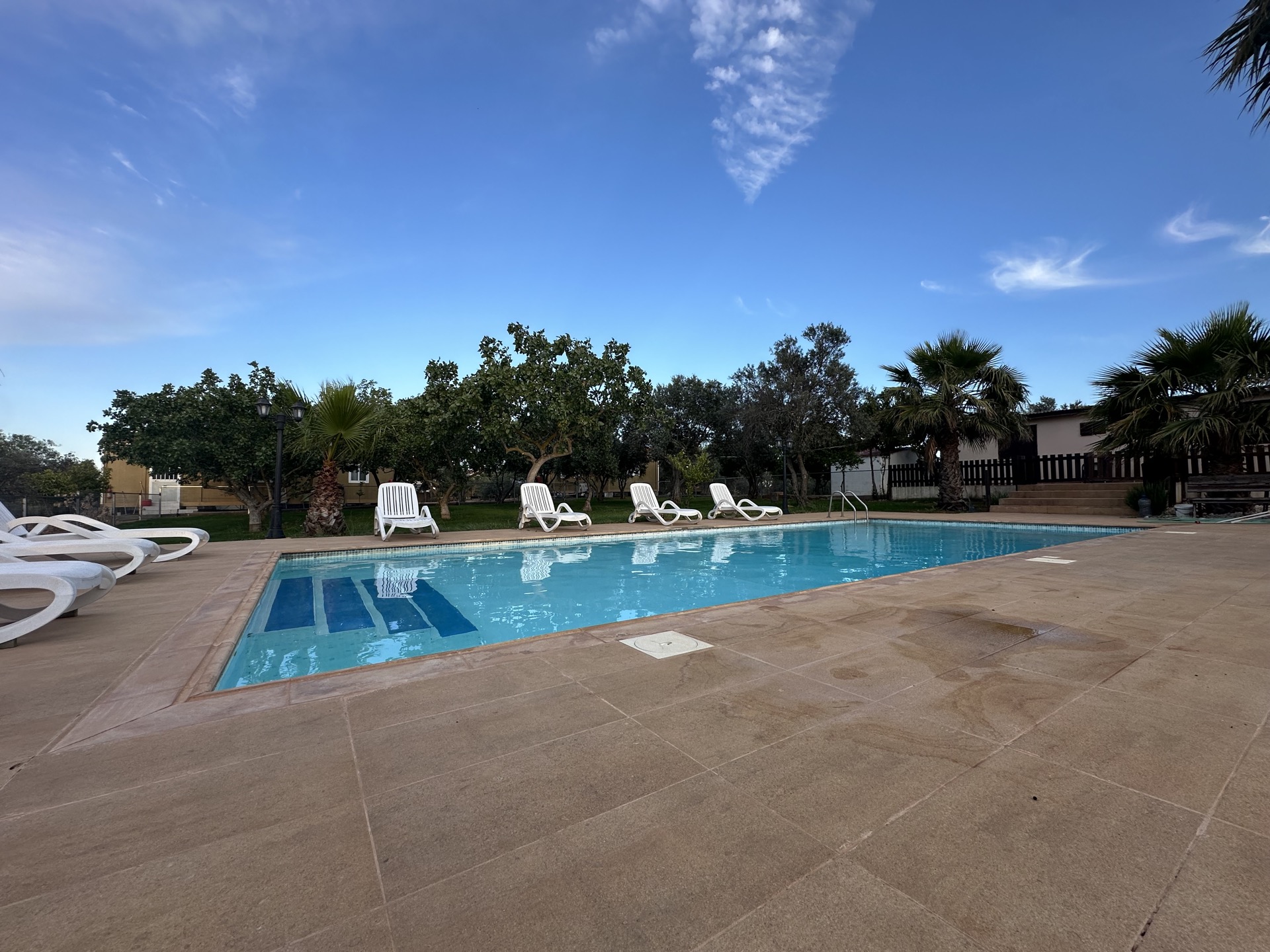 Pool and gardens at Holina Village Cyprus under blue sky